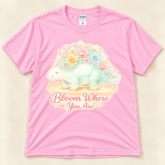 Bloom Where You Are Stegosaurus graphic tee in Light Pink featuring a kawaii floral stegosaurus with a positive inspirational saying from New Chapter Tees, a California small business.