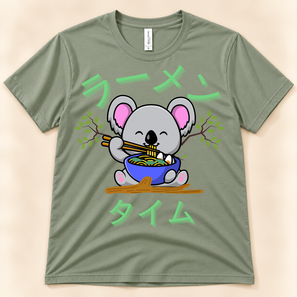 Sage Bella Canvas 3001 kawaii ramen tee featuring a cute koala eating noodles with Japanese Ramen Time artwork.