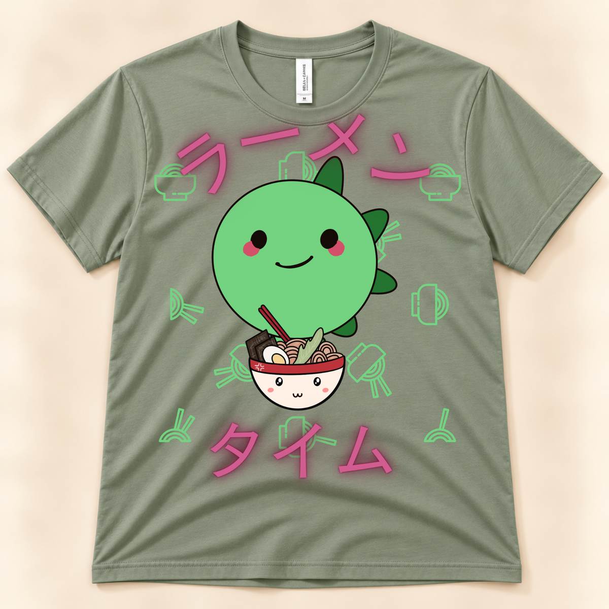 Sage Bella Canvas 3001 ramen graphic tee featuring a kawaii green stegosaurus, noodle bowl and Japanese Ramen Time artwork.