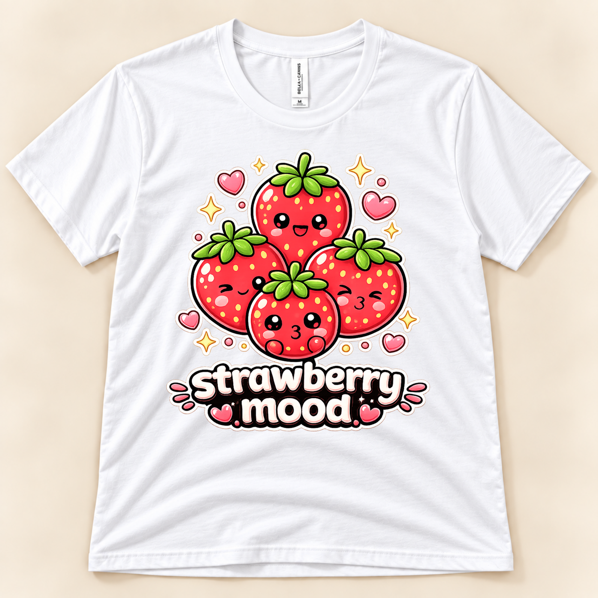White Bella Canvas 3001 Strawberry Mood graphic tee featuring four smiling cartoon strawberries surrounded by pink hearts and golden sparkles from New Chapter Tees, a California small business.
