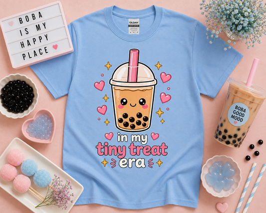 Pastel Carolina blue kawaii boba tea graphic tee with in my tiny treat era saying styled in cute bubble tea shop flat lay aesthetic for soft life fashion lovers and trendy snack themed apparel in the USA