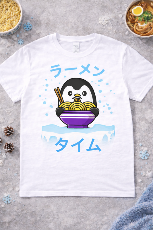 Kawaii penguin ramen graphic tee on white shirt featuring cute cartoon penguin eating noodles with chopsticks, Japanese ramen text, winter anime foodie design flatlay with snow and ramen bowls