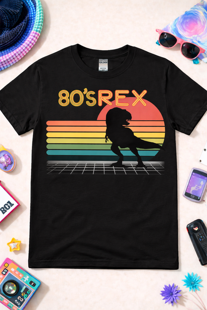 Black dinosaur graphic tee with retro 80s T-Rex design, neon sunset, and synthwave grid, styled in a vibrant flat lay with colorful accessories