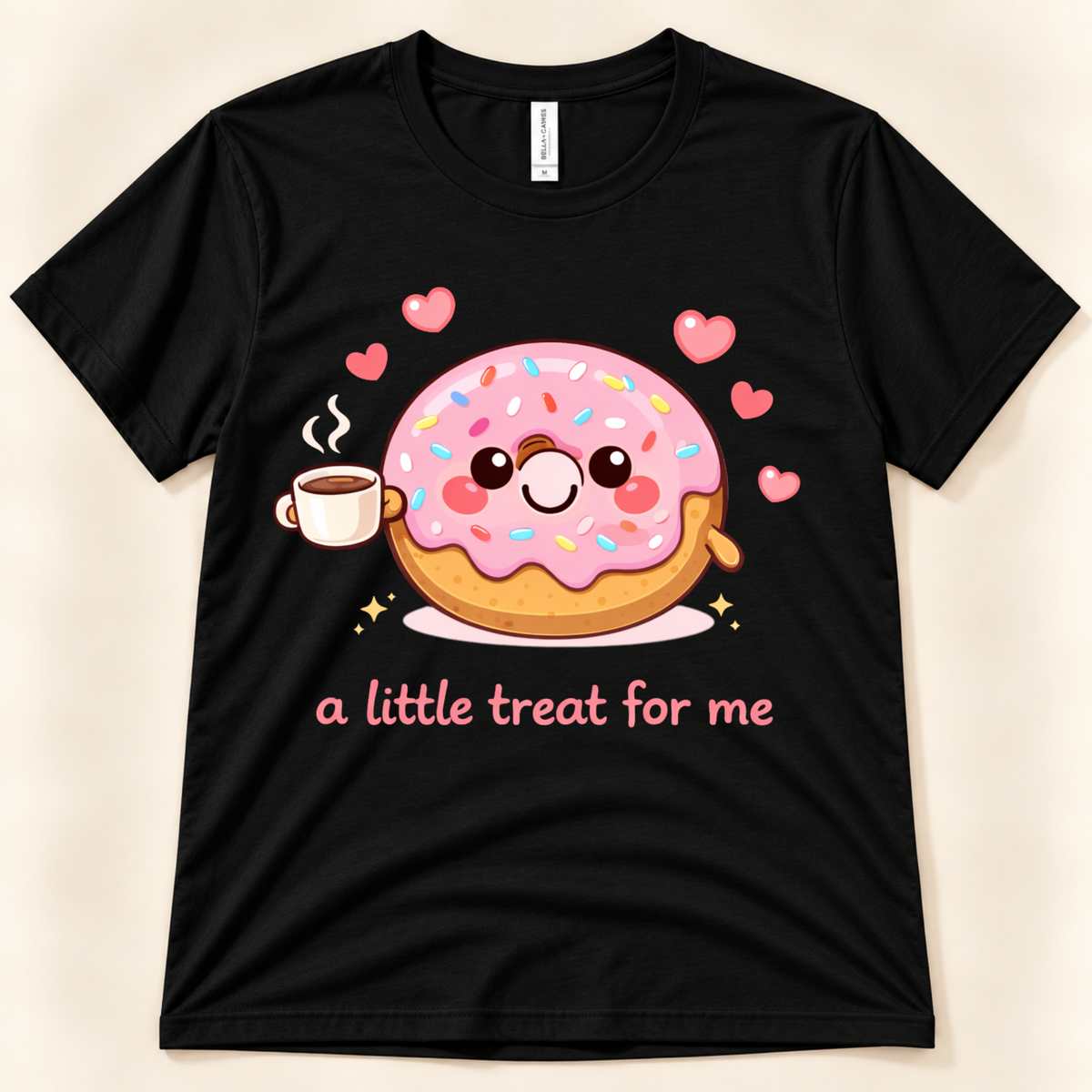 Black Bella Canvas 3001 donut graphic tee featuring a smiling pink frosted donut holding a coffee cup, surrounded by hearts and the A Little Treat For Me saying from New Chapter Tees, a California small business.