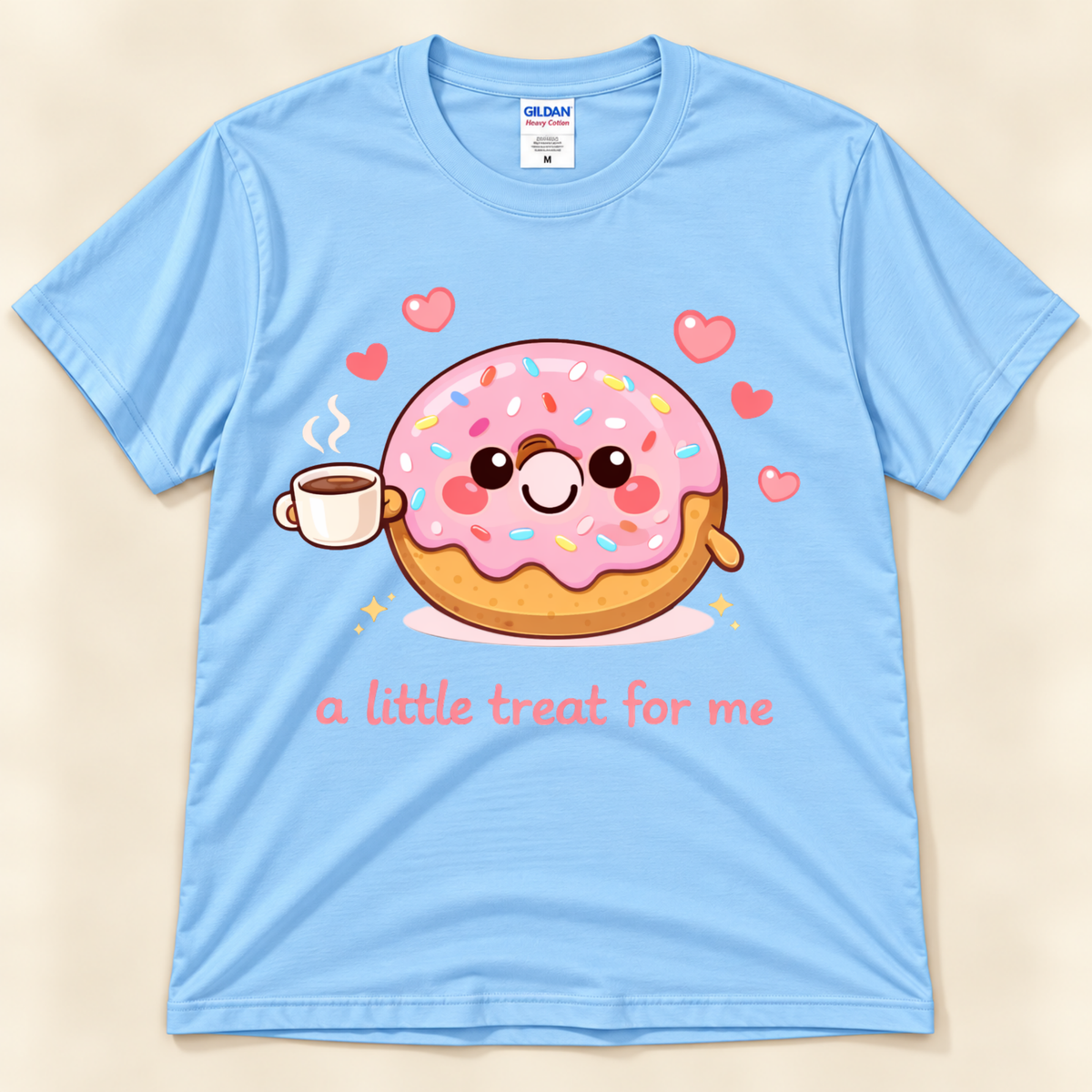 Light Blue Gildan 5000 donut graphic shirt featuring a smiling pink sprinkle donut holding coffee, floating hearts, and the A Little Treat For Me saying from New Chapter Tees, a California small business.