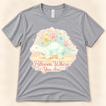 Bloom Where You Are Stegosaurus graphic tee in Athletic Heather featuring a cute pastel dinosaur covered in colorful flowers from New Chapter Tees, a California small business.