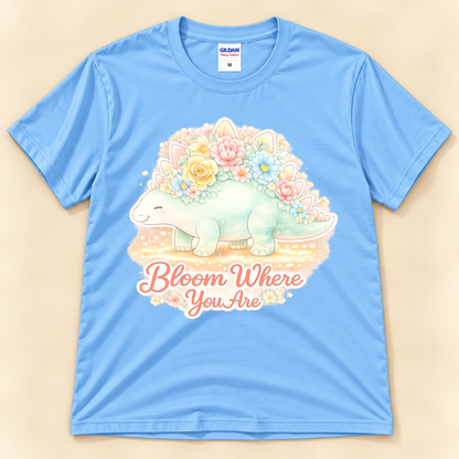 Bloom Where You Are Stegosaurus graphic tee in Carolina Blue featuring a cute pastel floral dinosaur and inspirational quote from New Chapter Tees, a California small business.
