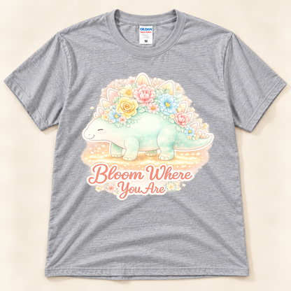 Bloom Where You Are Stegosaurus graphic tee in Sport Gray featuring a cute pastel stegosaurus covered in colorful flowers from New Chapter Tees, a California small business.