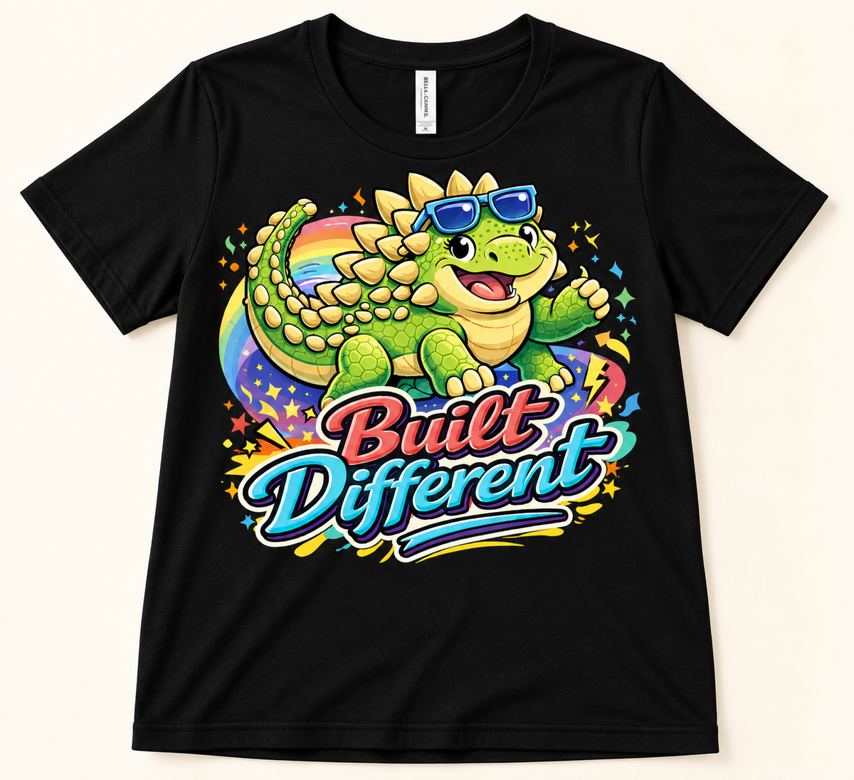 Black Bella Canvas 3001 Built Different Ankylosaurus Tee with green dinosaur, blue sunglasses and colorful rainbow graphic