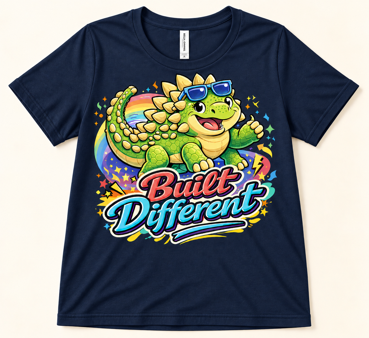 Navy Bella Canvas 3001 Built Different Ankylosaurus graphic tee featuring a green dinosaur in blue sunglasses with rainbow art
