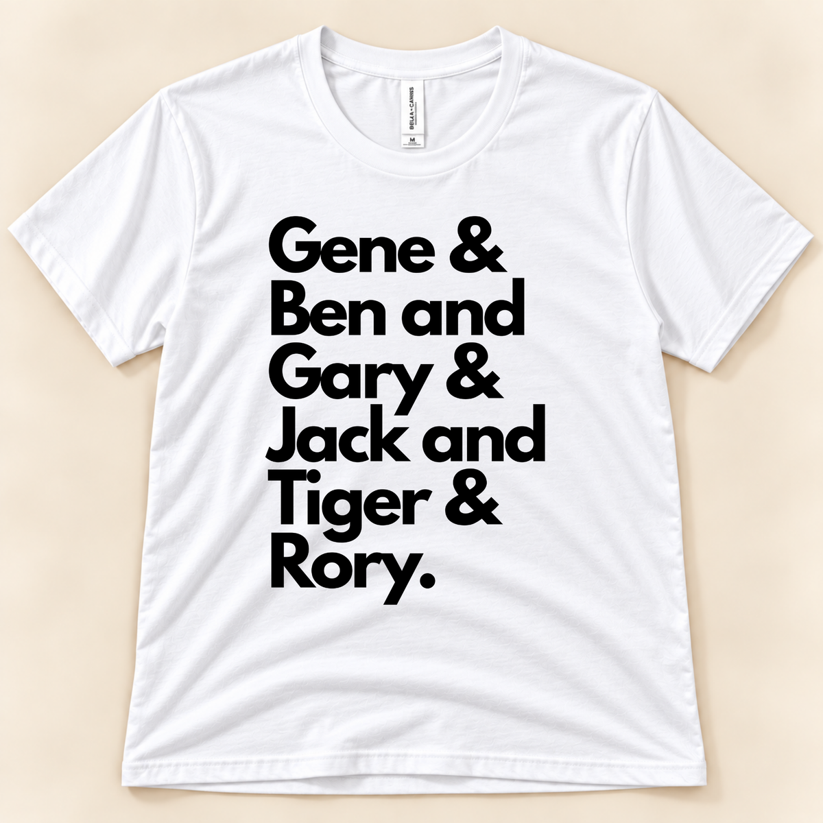 White Bella Canvas 3001 Career Grand Slam golf tee featuring black stacked typography reading Gene, Ben, Gary, Jack, Tiger and Rory, celebrating six golf legends from New Chapter Tees, a California small business.