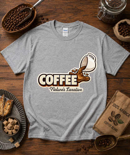 Coffee Natures Laxative coffee graphic printed on a sport gray Gildan 5000 classic heavy cotton shirt with coffee shop flat lay styling featuring roasted coffee beans espresso equipment baked pastries chocolate and rustic cafe props for coffee lovers and baristas