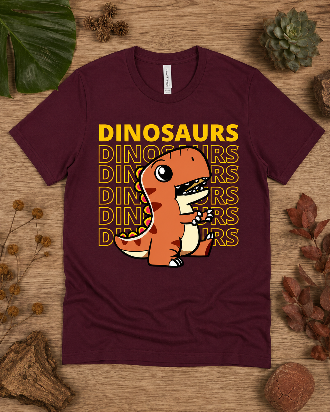 Orange T Rex Dinosaur Energy graphic tee on a maroon Bella Canvas 3001 premium soft shirt for adults, kids, and dinosaur lovers.