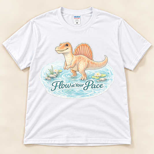 Flow at Your Pace Spinosaurus graphic tee in White featuring a cute dinosaur in a peaceful pond with an encouraging message from New Chapter Tees, a California small business.