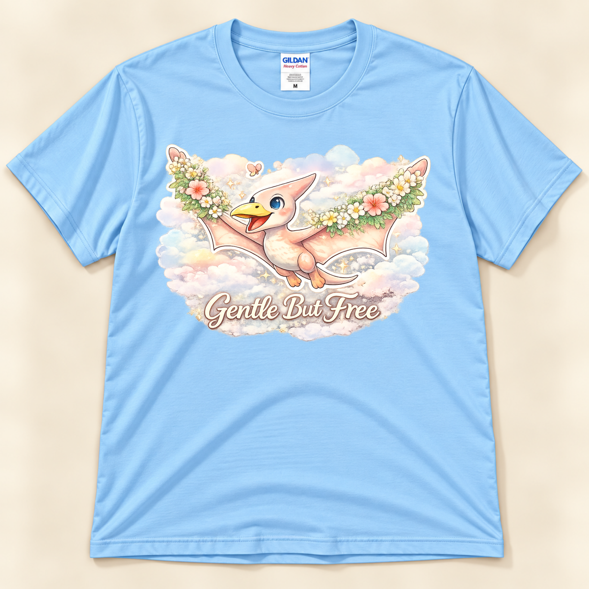 Gentle But Free pterodactyl graphic tee in Light Blue featuring a cute floral flying dinosaur among dreamy pastel clouds from New Chapter Tees, a California small business.