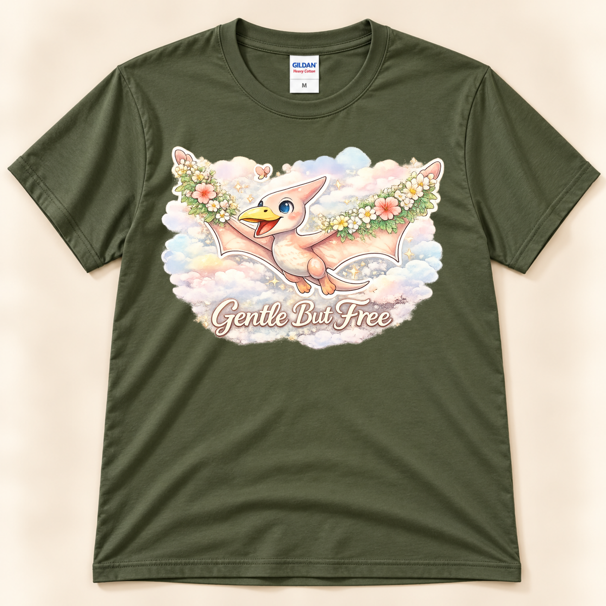 Gentle But Free pterodactyl graphic tee in Military Green featuring a floral flying dinosaur and pastel cloud artwork from New Chapter Tees, a California small business.