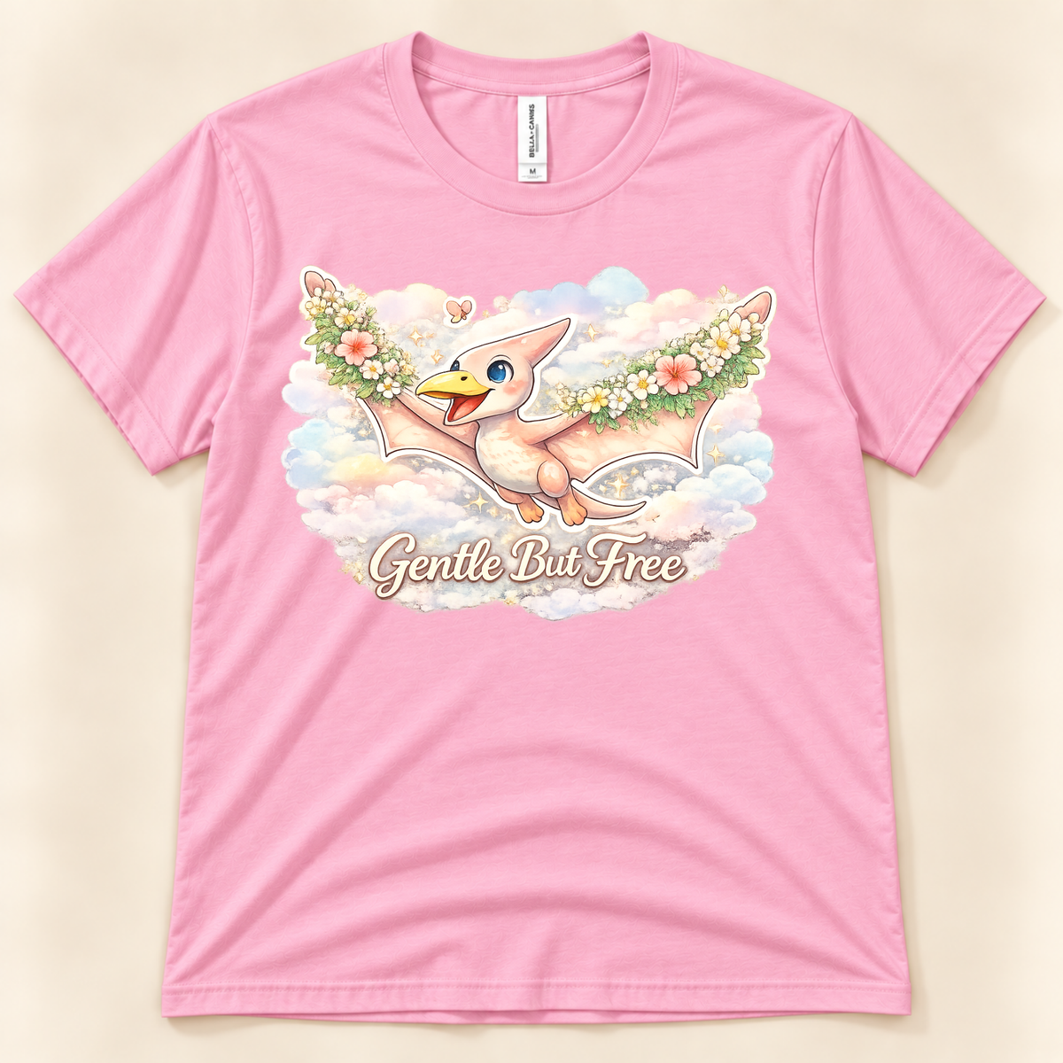 Gentle But Free cute pterodactyl graphic tee in Pink with floral wings and dreamy pastel clouds from New Chapter Tees, a California small business.