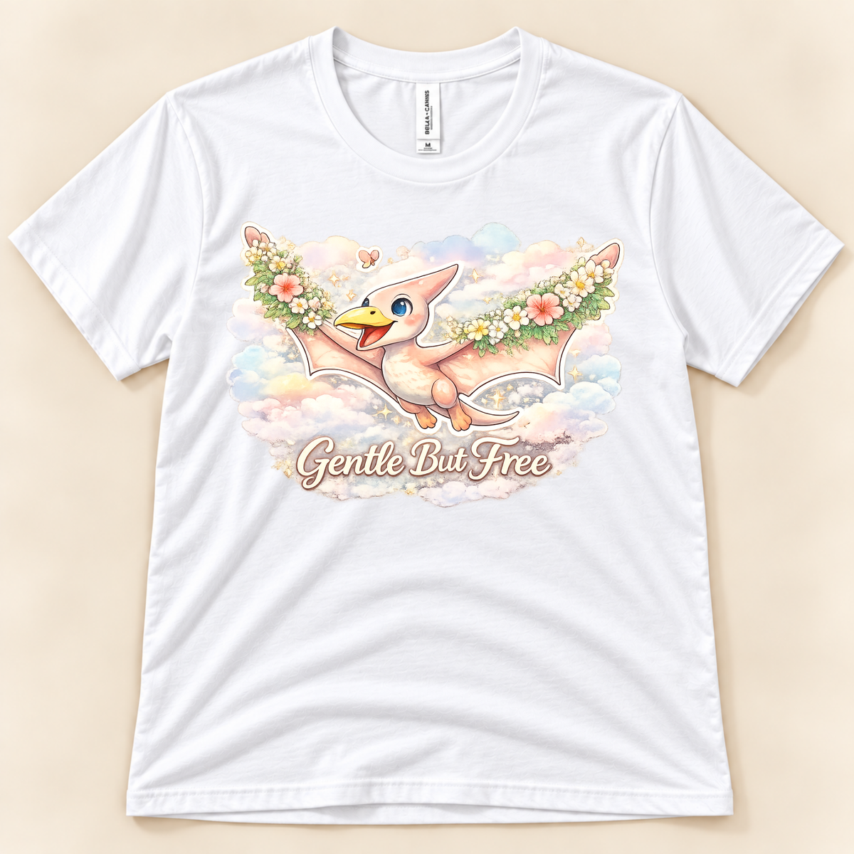 Gentle But Free pterodactyl graphic tee in White featuring a whimsical floral flying dinosaur and pastel clouds from New Chapter Tees, a California small business.