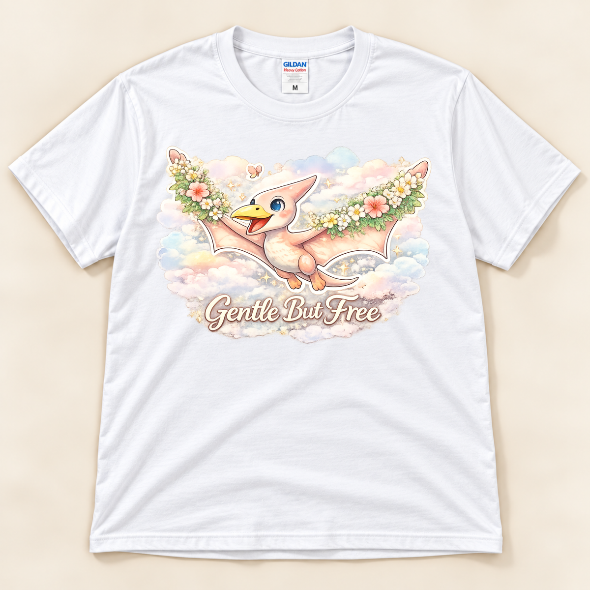 Gentle But Free pterodactyl graphic tee in White featuring a whimsical floral dinosaur flying through pastel clouds from New Chapter Tees, a California small business.