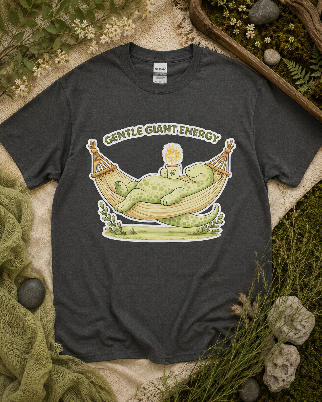 Gentle Giant Energy dinosaur shirt on Charcoal Gildan Heavy Cotton featuring watercolor dinosaur hammock artwork for relaxed casual fashion in the USA.