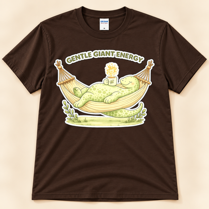Dark Chocolate Gildan 5000 Gentle Giant Energy shirt featuring a cozy green brontosaurus relaxing in a hammock with a warm drink.