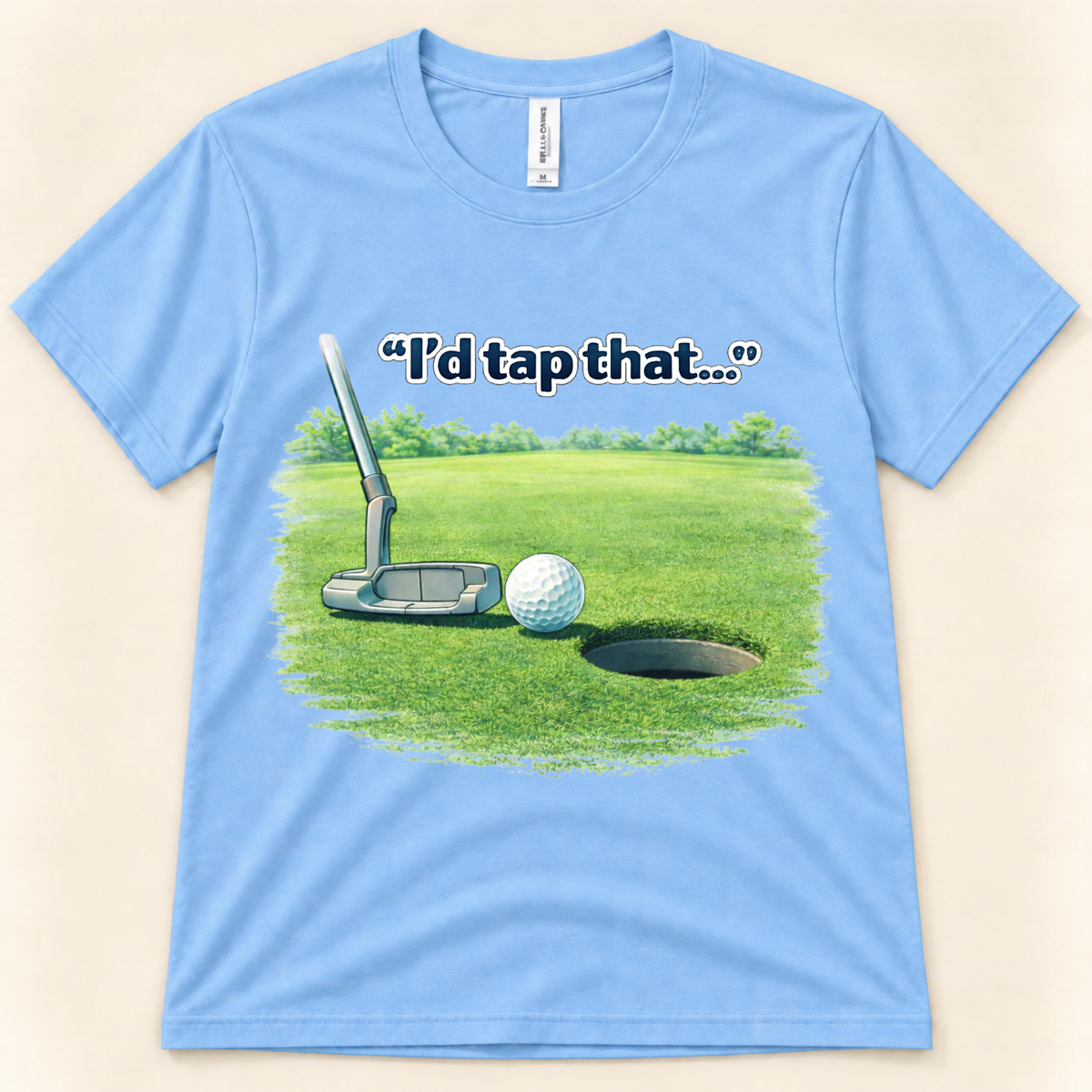 Carolina Blue Bella Canvas 3001 I’d Tap That golf graphic tee featuring a putter and golf ball beside the hole for golfers from New Chapter Tees, a California small business.