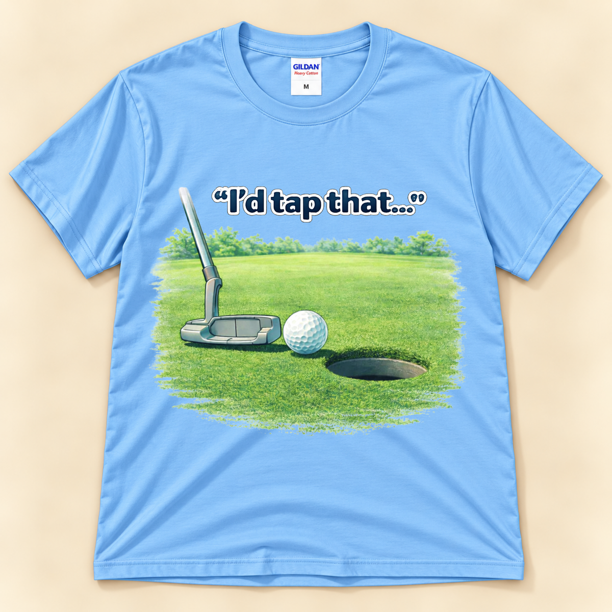 Carolina Blue Gildan 5000 I’d Tap That golf graphic tee featuring a putter and golf ball beside the cup on a putting green from New Chapter Tees, a California small business.