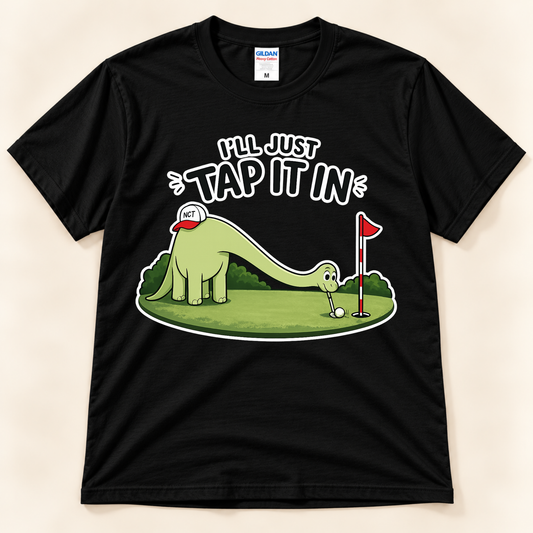 Black Gildan 5000 I’ll Just Tap It In golf tee featuring Brussel the Brontosaurus putting a golf ball with a funny golf saying from New Chapter Tees, a California small business.