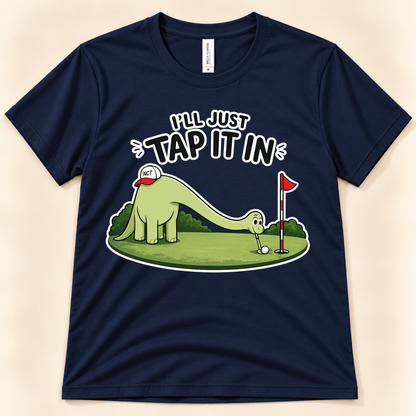 Navy Bella Canvas 3001 I’ll Just Tap It In golf graphic tee featuring Brussel the Brontosaurus putting a golf ball for dinosaur and golf lovers from New Chapter Tees, a California small business.