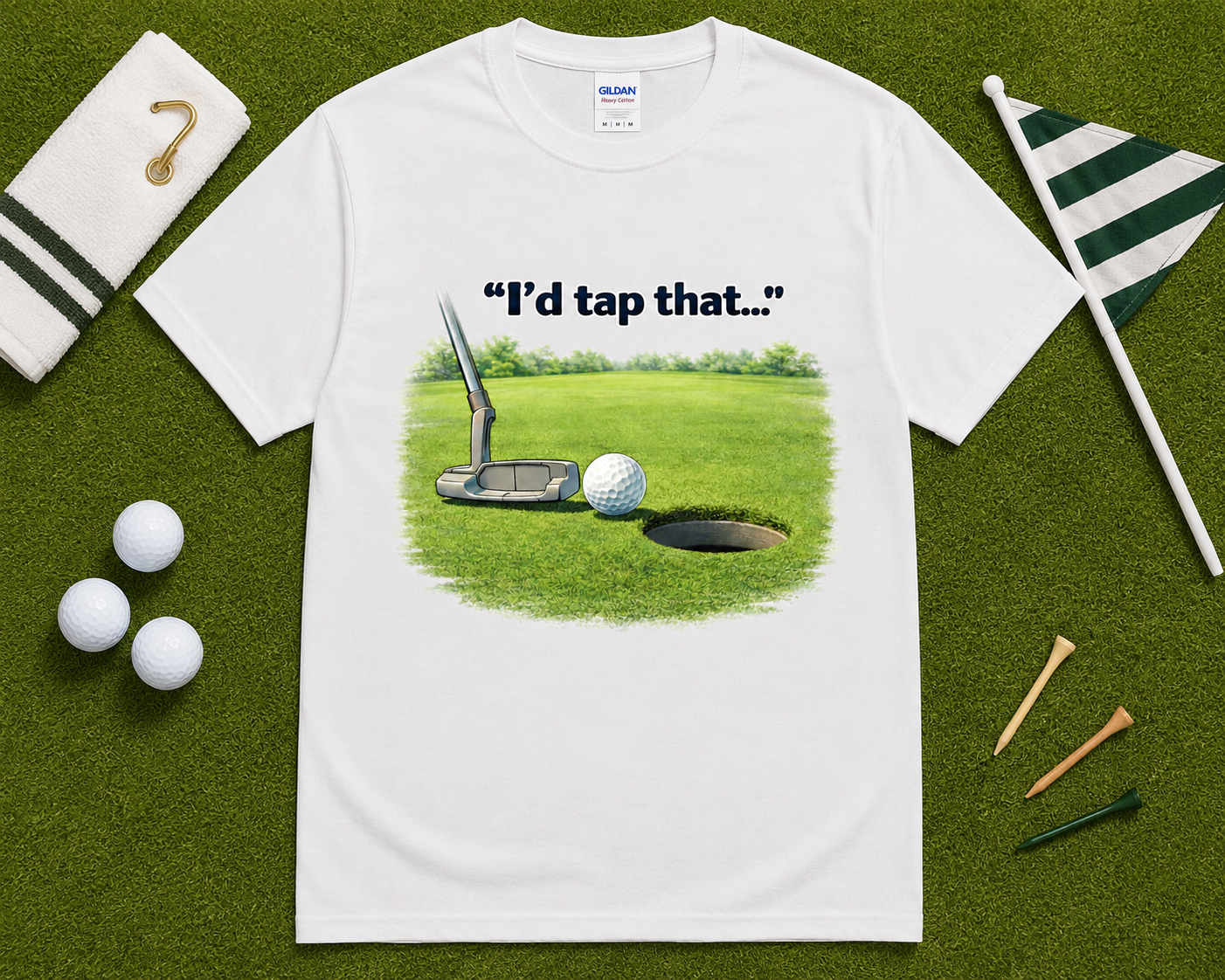 White golf graphic t shirt flatlay with I'd Tap That putting design and golf accessories, funny golf lover gift shirt for casual and competitive golfers.