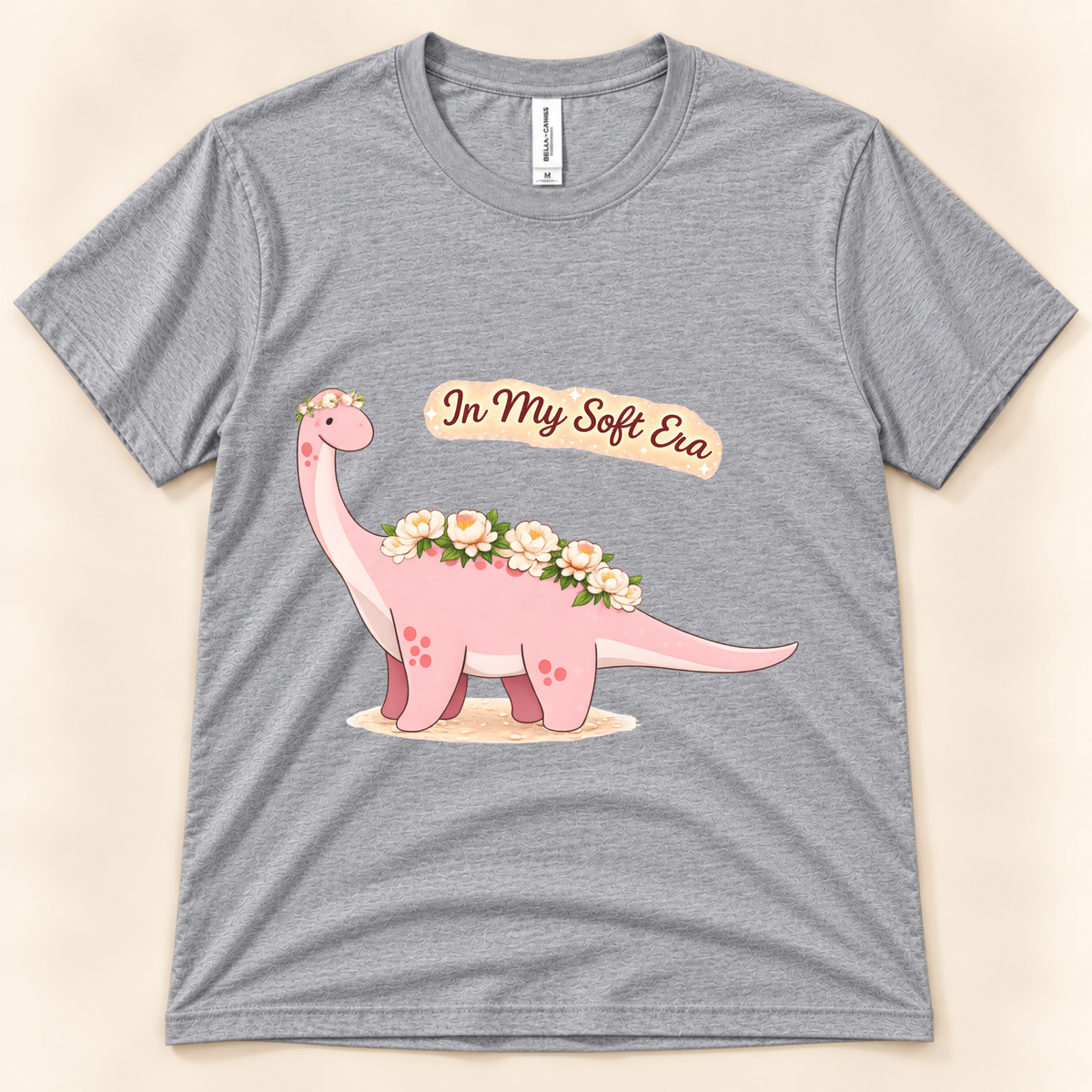 Athletic Heather Bella Canvas 3001 In My Soft Era graphic tee featuring a cute pink Brontosaurus decorated with flowers from New Chapter Tees, a California small business.