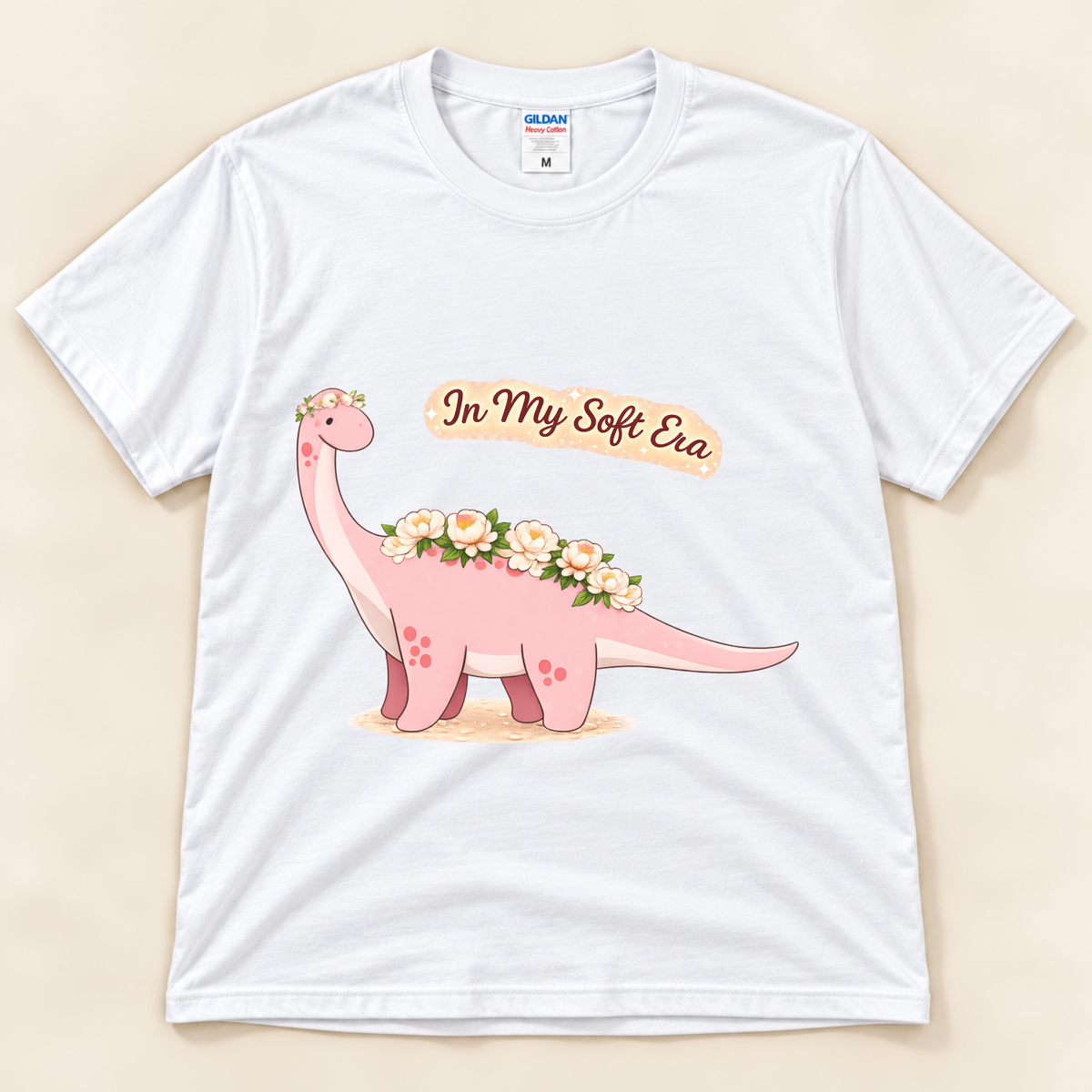 White Gildan 5000 In My Soft Era dinosaur graphic tee featuring a cute pink Brontosaurus with floral details and soft life artwork from New Chapter Tees, a California small business.