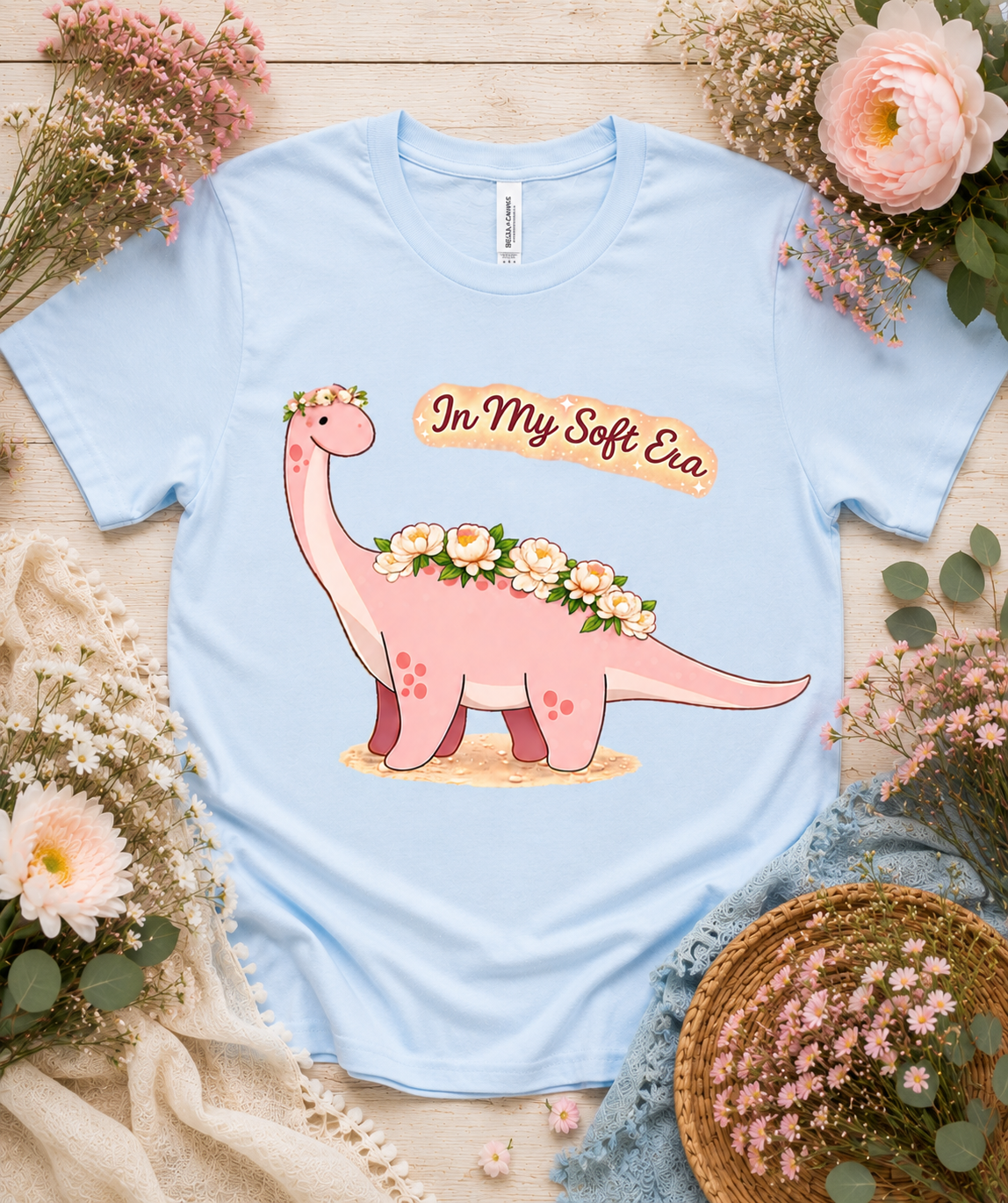 Bella Canvas 3001 baby blue dinosaur graphic tee featuring In My Soft Era floral pink dinosaur design soft aesthetic gift for women girls USA