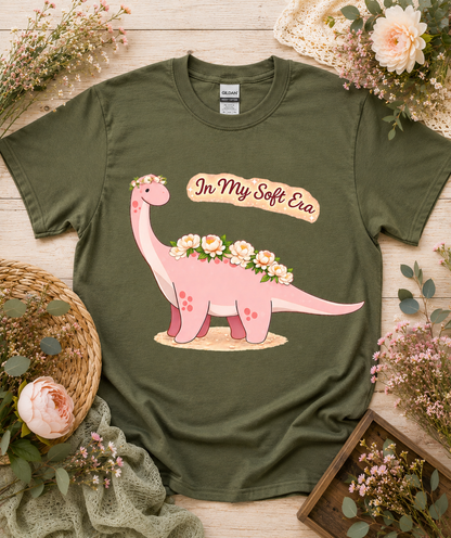 Cute floral pink dinosaur graphic tee on military green Gildan 5000 shirt featuring In My Soft Era artwork unique soft aesthetic dinosaur gift USA
