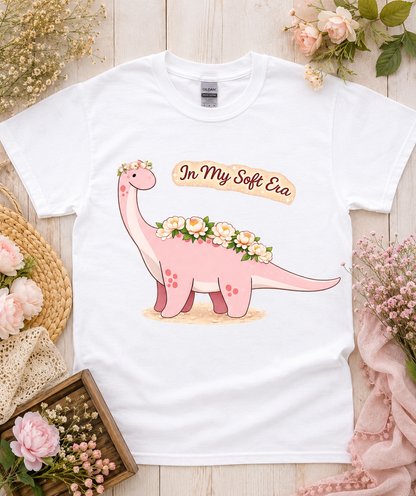 Cute In My Soft Era pink dinosaur graphic tee on white Gildan 5000 shirt with floral flat lay perfect for women girls soft aesthetic dinosaur lovers California USA