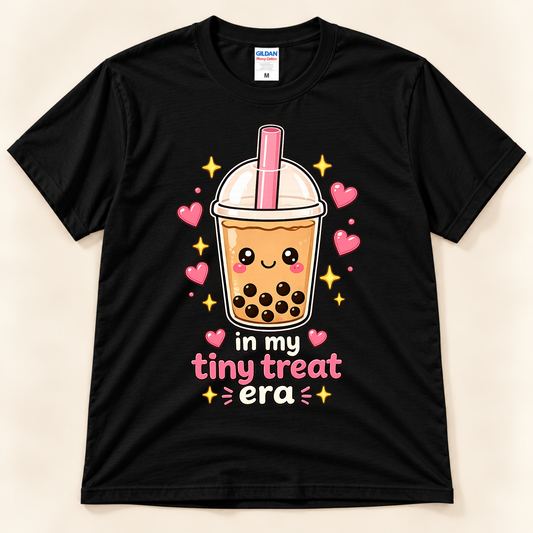 Black Gildan 5000 bubble tea graphic tee featuring a cute smiling boba milk tea cup with pink straw, black tapioca pearls, hearts, and In My Tiny Treat Era saying from New Chapter Tees, a California small business.