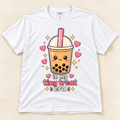 White Gildan 5000 cute foodie graphic tee featuring a smiling boba milk tea cup with pink straw, tapioca pearls, hearts, and In My Tiny Treat Era lettering from New Chapter Tees, a California small business.