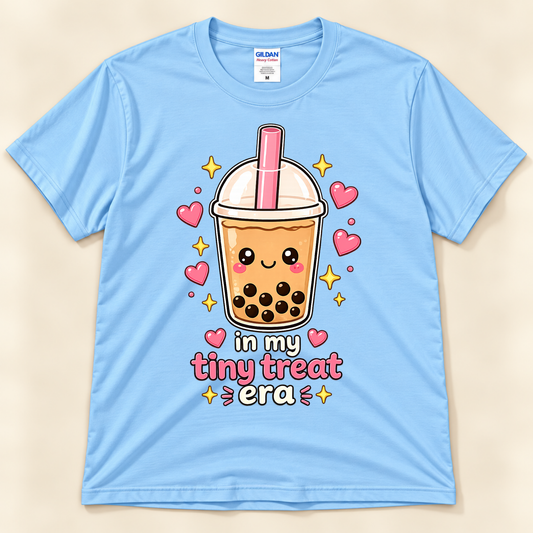 Light Blue Gildan 5000 kawaii boba graphic tee featuring a smiling milk tea cup, pink straw, tapioca pearls, floating hearts, and In My Tiny Treat Era lettering from New Chapter Tees, a California small business.