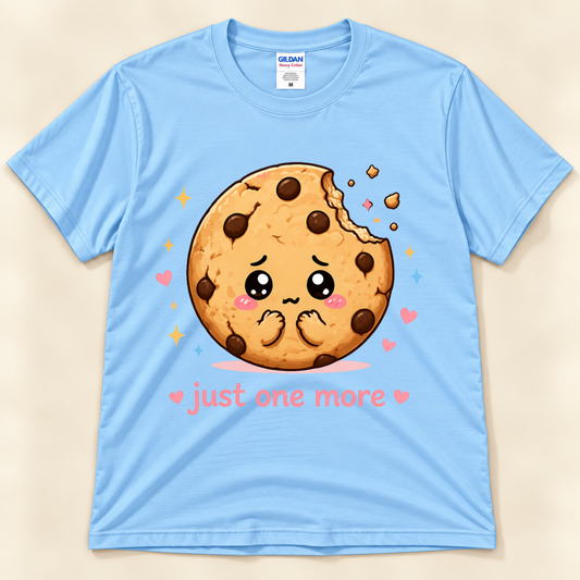 Light Blue Gildan 5000 Just One More Cookie graphic shirt featuring an adorable bitten chocolate chip cookie with pink hearts, sparkles and a funny sweet treat saying from New Chapter Tees, a California small business.