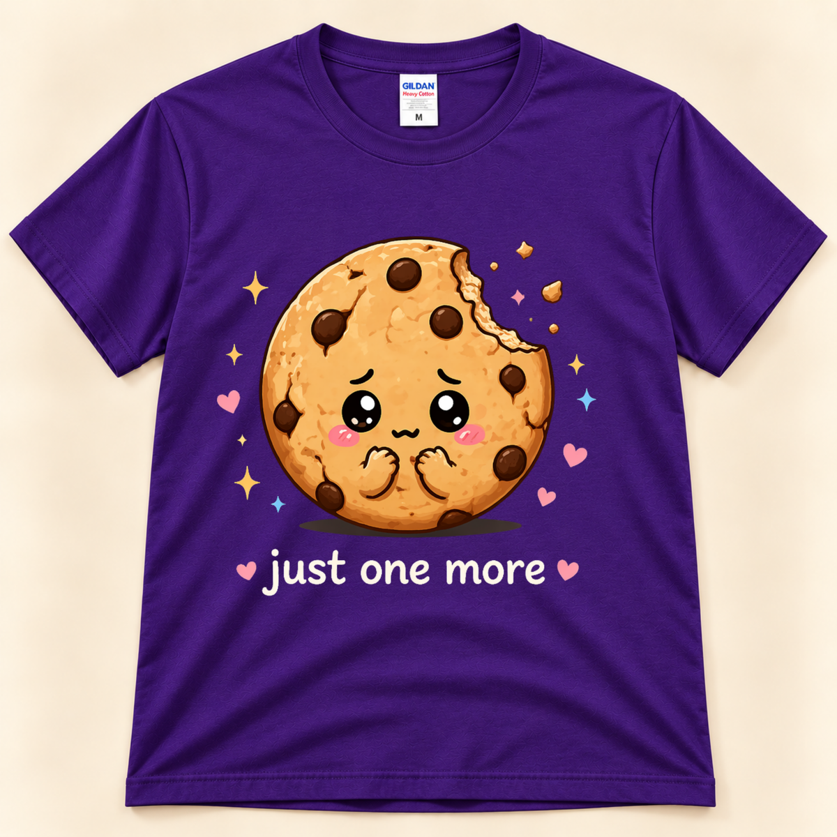 Purple Gildan 5000 Just One More Cookie graphic tee featuring an adorable bitten chocolate chip cookie, colorful hearts, sparkles and a playful cookie lover saying from New Chapter Tees, a California small business.