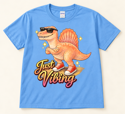 Carolina Blue Gildan 5000 Just Vibing dinosaur shirt with colorful Spinosaurus, sunglasses and retro graphic