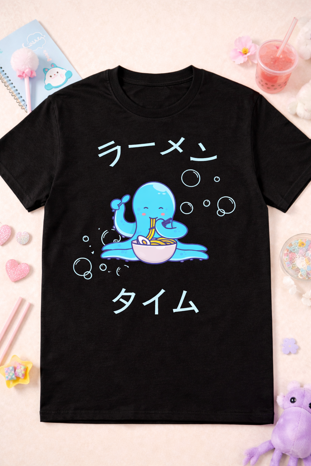 Black kawaii octopus ramen graphic tee with cute anime design and Japanese text, styled with pastel props and playful foodie aesthetic flatlay.
