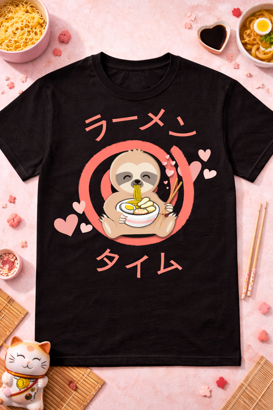 Black kawaii sloth eating ramen graphic tee with anime-style design and Japanese text, styled with ramen bowls, chopsticks, and cozy pink foodie flatlay props.