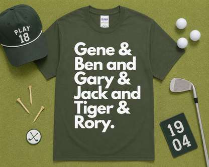 Military Green Gildan 5000 funny golf graphic tee flatlay with Gene Ben Gary Jack Tiger Rory design and golf accessories on light green grass, golfer gift, unisex golf clothing for golf enthusiasts in the USA.