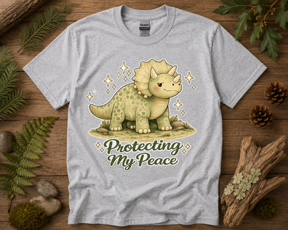 Protecting My Peace dinosaur graphic tee on sport gray Gildan 5000 featuring cozy woodland triceratops artwork