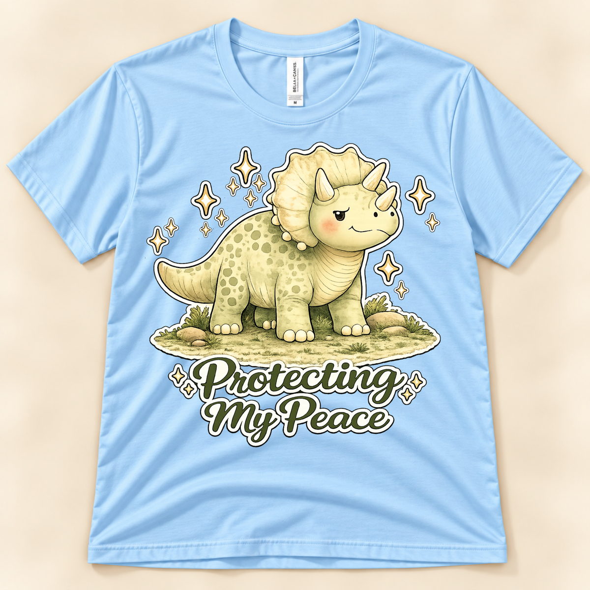 Baby Blue Bella Canvas 3001 Protecting My Peace graphic tee featuring a cute Triceratops and positive self care message from New Chapter Tees, a California small business.