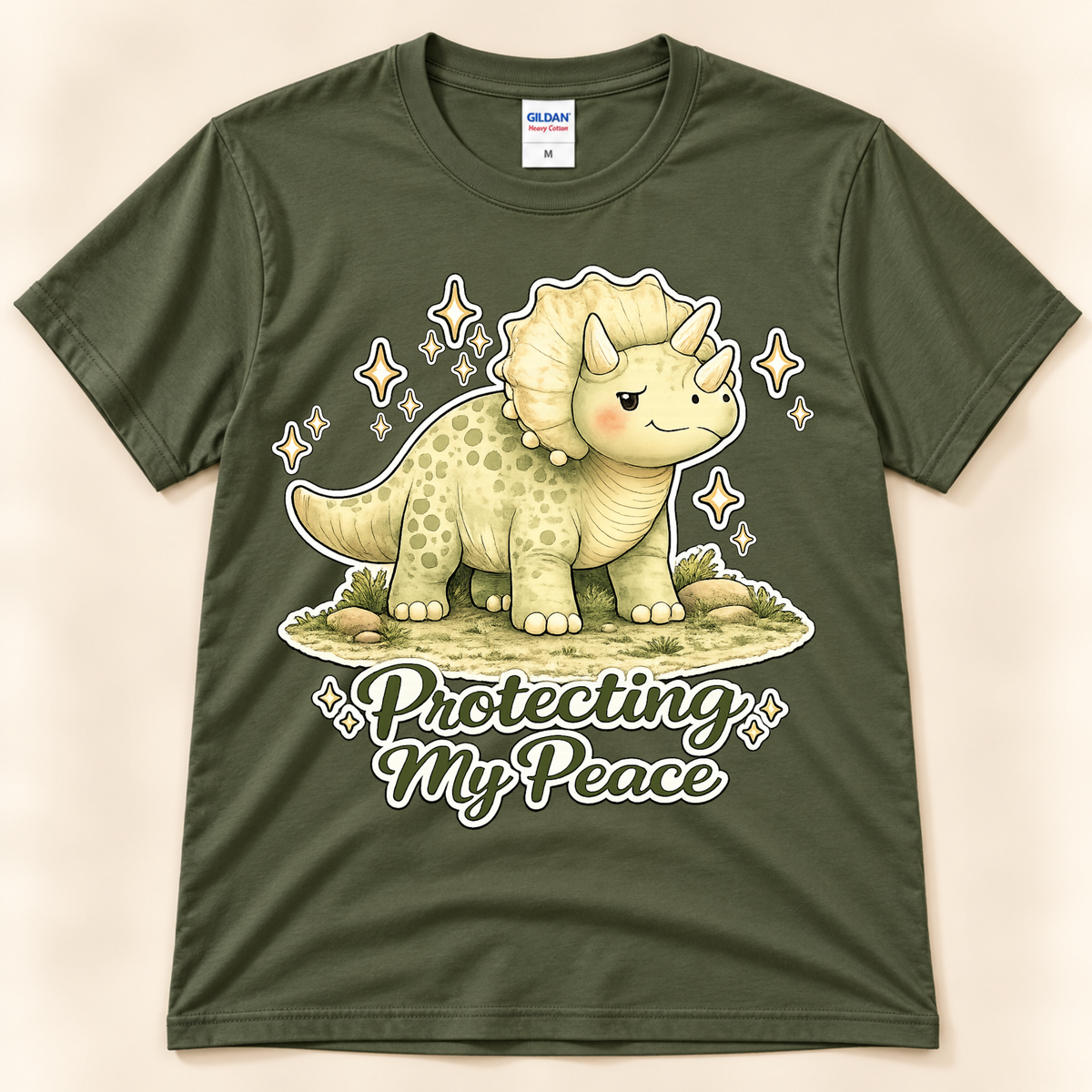 Military Green Gildan 5000 Protecting My Peace Triceratops graphic tee featuring a cute dinosaur and positive motivational saying from New Chapter Tees, a California small business.