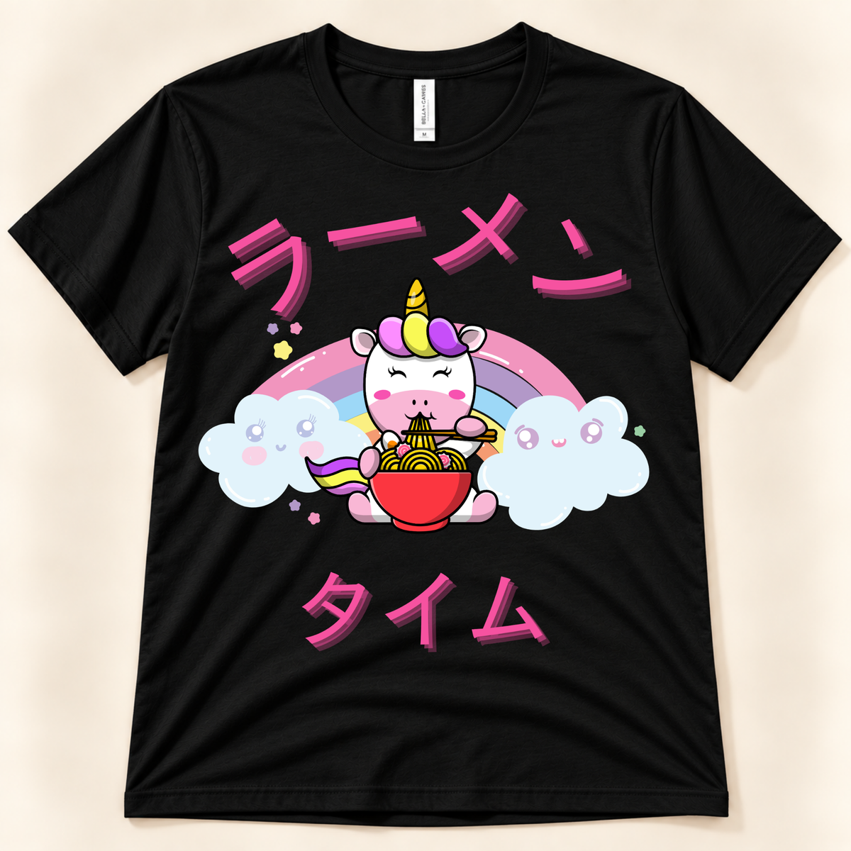 Black Bella Canvas unicorn ramen tee with colorful kawaii artwork and pink Japanese lettering.