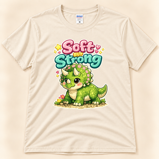 Soft But Strong triceratops graphic tee in Natural by New Chapter Tees, a California small business, featuring a cute green dinosaur design.