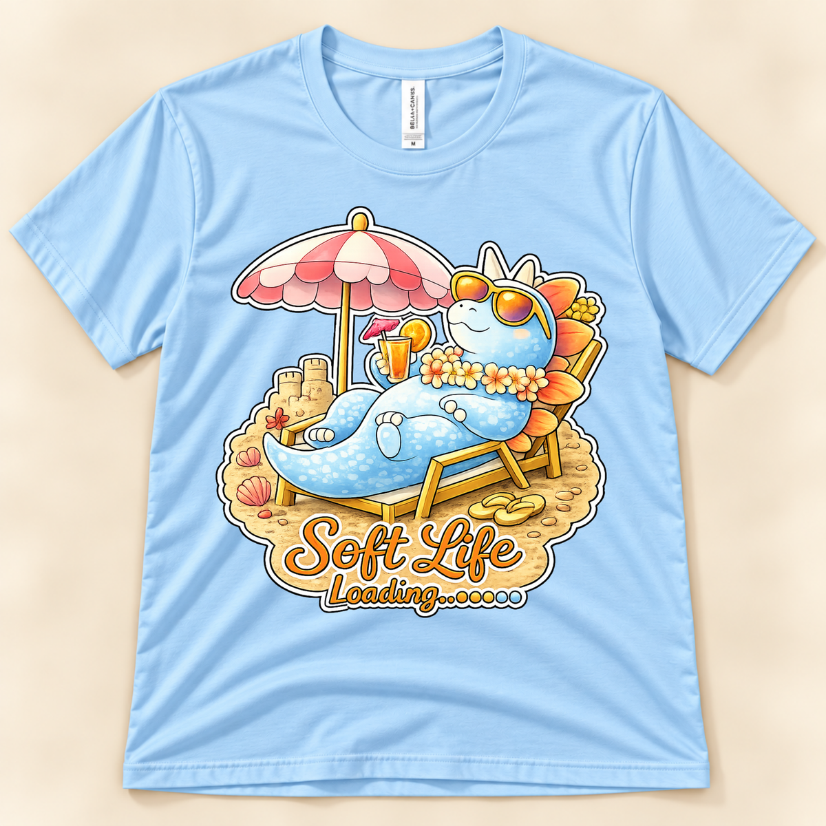 Baby Blue Bella Canvas 3001 Soft Life Loading graphic tee featuring a cute Stegosaurus relaxing on the beach from New Chapter Tees, a California small business.